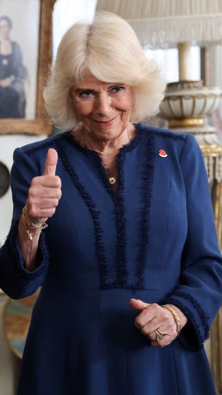 Queen Camilla with her thumb up.