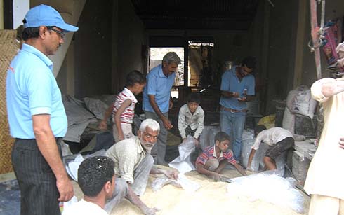 Brooke personnel help bag feed