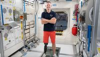John McFall stands in a mockup International Space Station module.