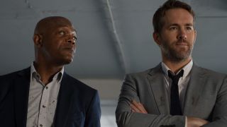 Samuel L Jackson casually looks over at a frustrated Ryan Reynolds in The Hitman's Bodyguard.