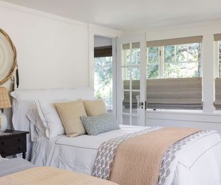 bedroom with half blinds and soft neutral colors and wooden floors