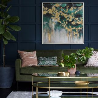 Blue panelled living room with green velvet sofa and gold coffee table