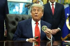 U.S. President Donald Trump holds a coin