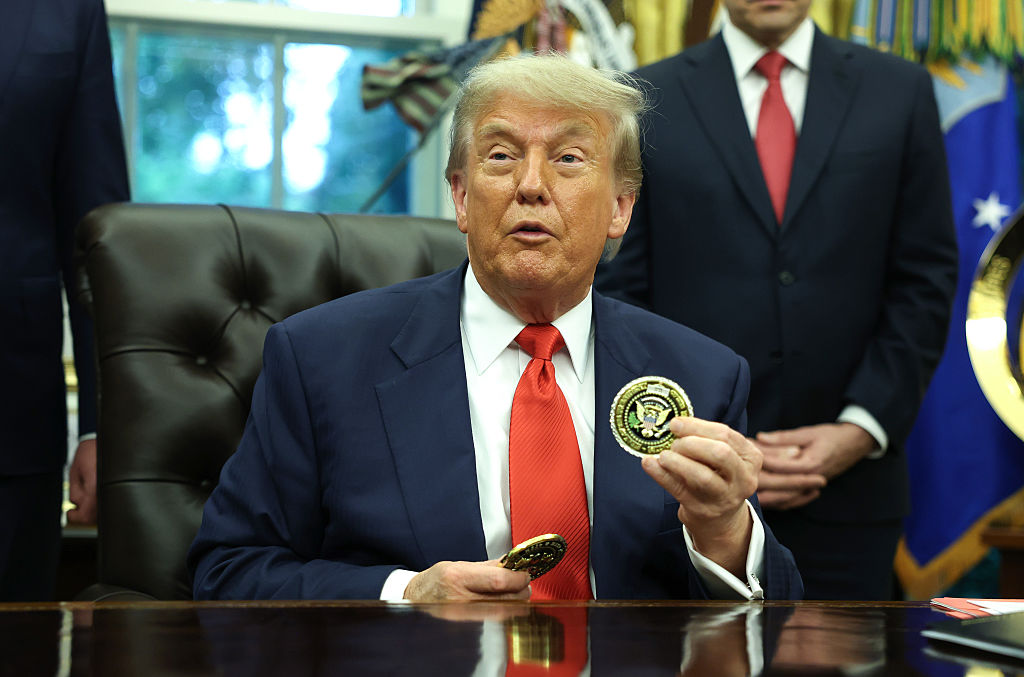U.S. President Donald Trump holds a coin