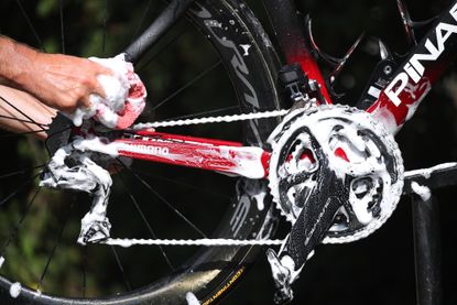 Image shows road bike drivechain being cleaned with a sponge