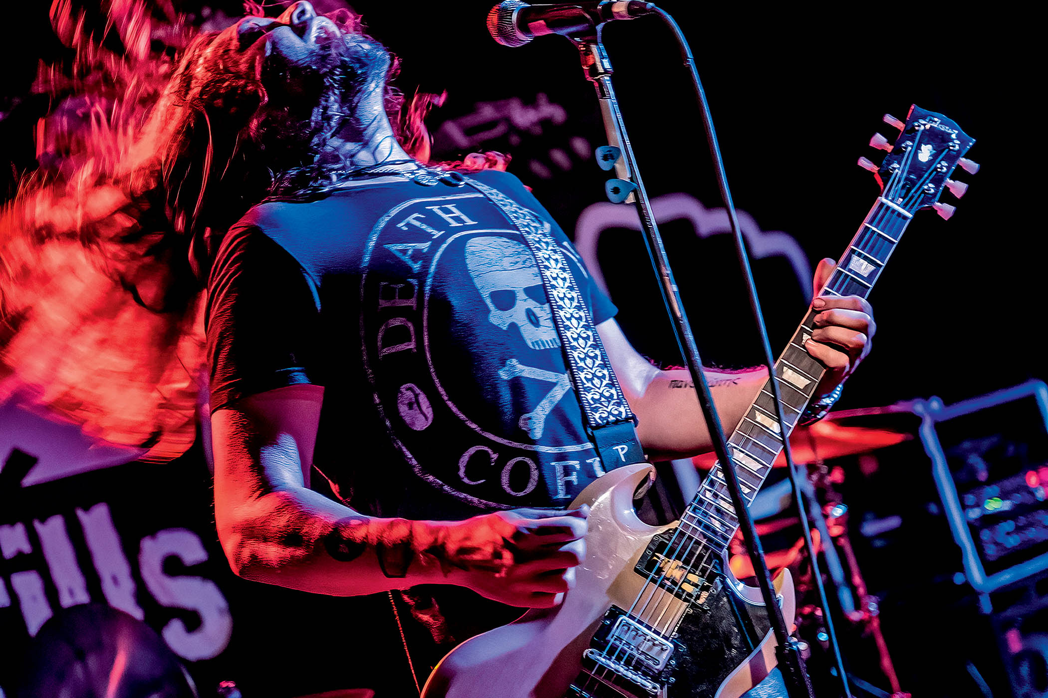 Phil X headbangs as he plays live with a Gibson SG