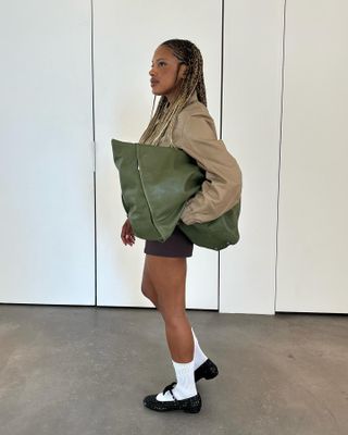 Influencer wears an olive green bag.