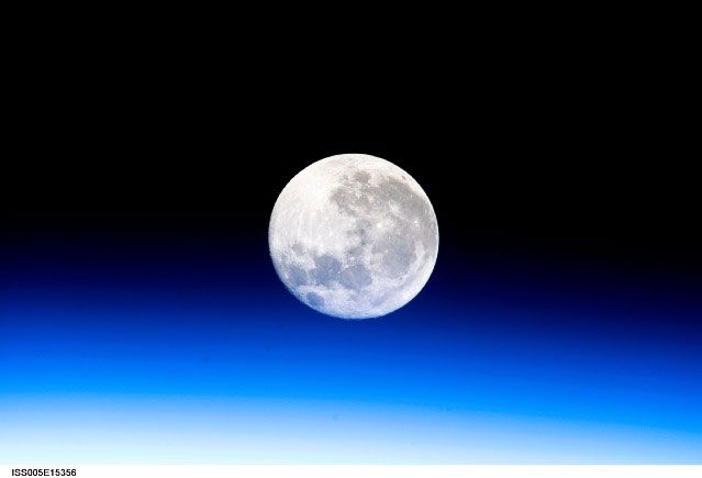 A full moon is visible in this view above Earth&#039;s horizon and airglow, photographed by Expedition 10 Commander Leroy Chiao on the International Space Station.