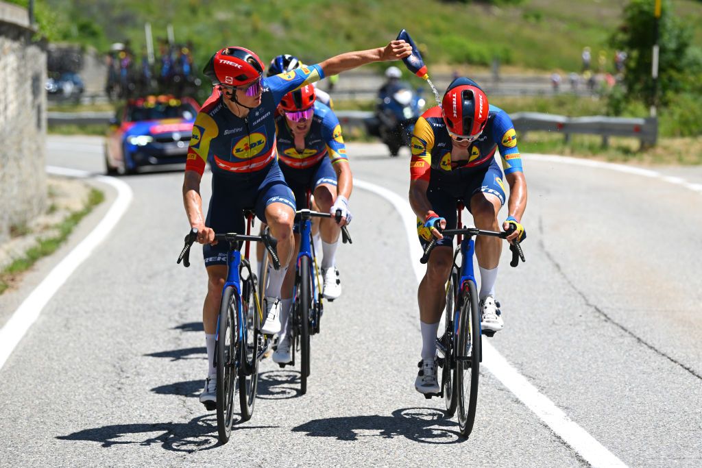 VALLOIRE FRANCE JULY 02 LR Toms Skujins of Latvia cools off to Jasper Stuyven of Belgium and Team Lidl Trek dropped from the peloton during the 111th Tour de France 2024 Stage 4 a 1394km stage from Pinerolo to Valloire UCIWT on July 02 2024 in Valloire France Photo by Dario BelingheriGetty Images