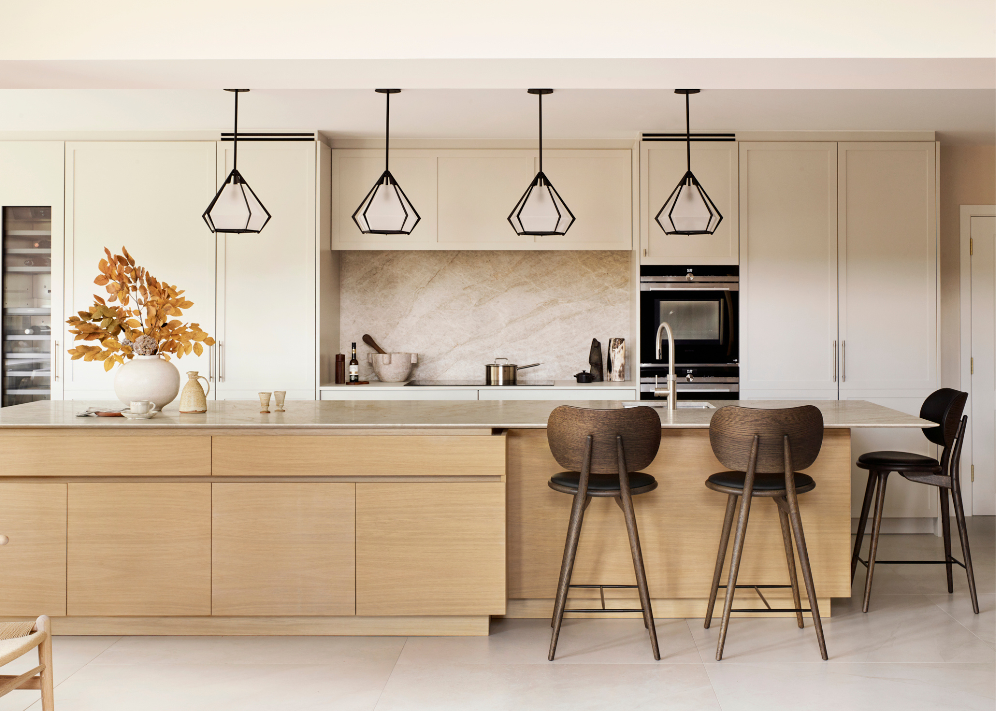 modern airy and light kitchen with white cabinet a wooden island and dark wooden sculptural stools