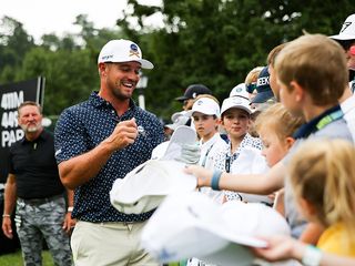 Bryson DeChambeau signing autographs and engaging with fans on the golf course