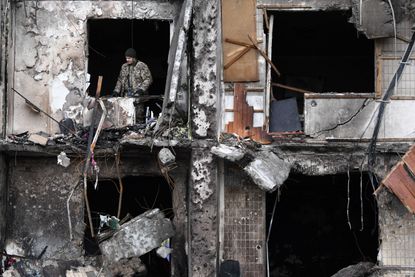 A person looks out at the destruction in Ukraine