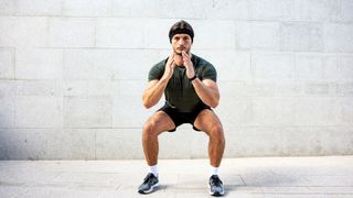 a photo of a man doing a squat