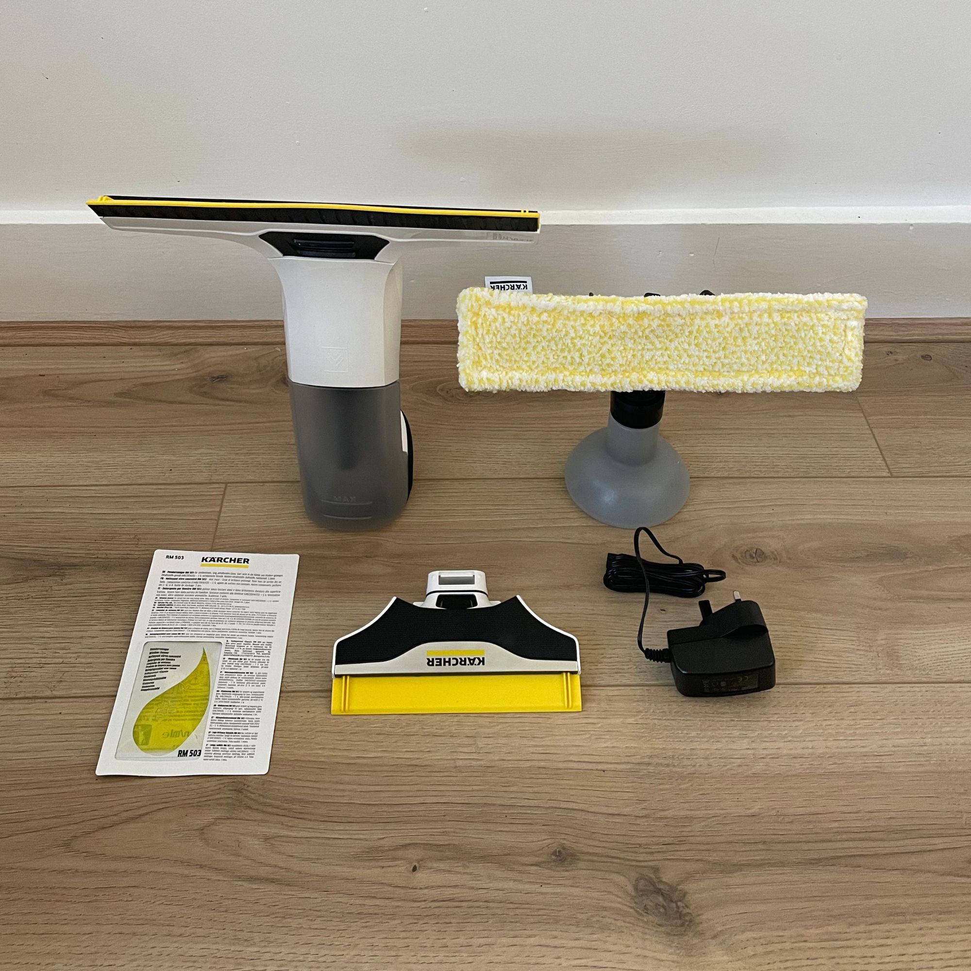 Karcher Window Vac and accessories laying on wood-effect flooring
