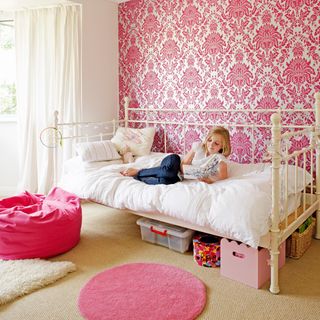 children's bedroom with pink wallpaper and carpet floor