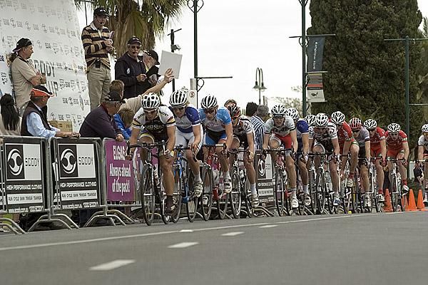 The peloton head pass the podium in Mildura in pursuit of a leading group.