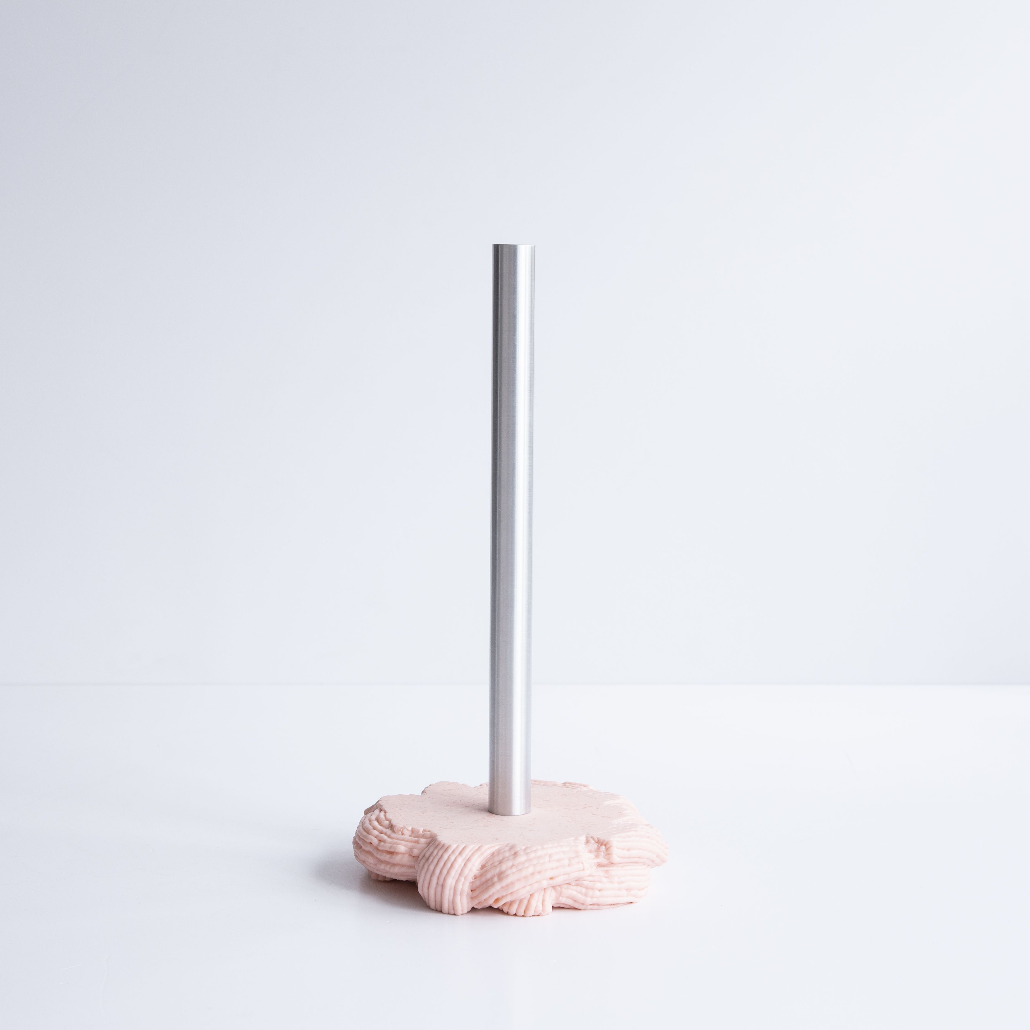 A series of squishy home objects designed from melted plastic and chrome or brass detailing, including a mirror, candelabra, and a kitchen towel rack.