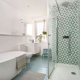 bathroom with green and white tiles and shower