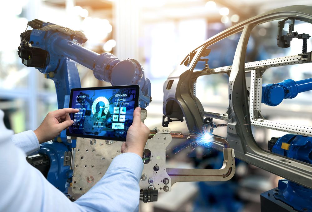 A factory worker using a tablet in an industrial setting