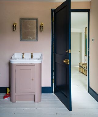Pink vanity unit and walls contrasted with navy woodwork