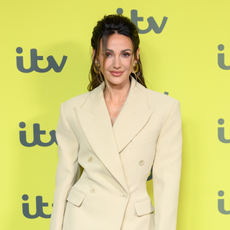 Michelle Keegan in beige suit in front of yellow ITV background.