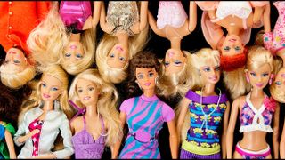 A pile of Barbie dolls in a row