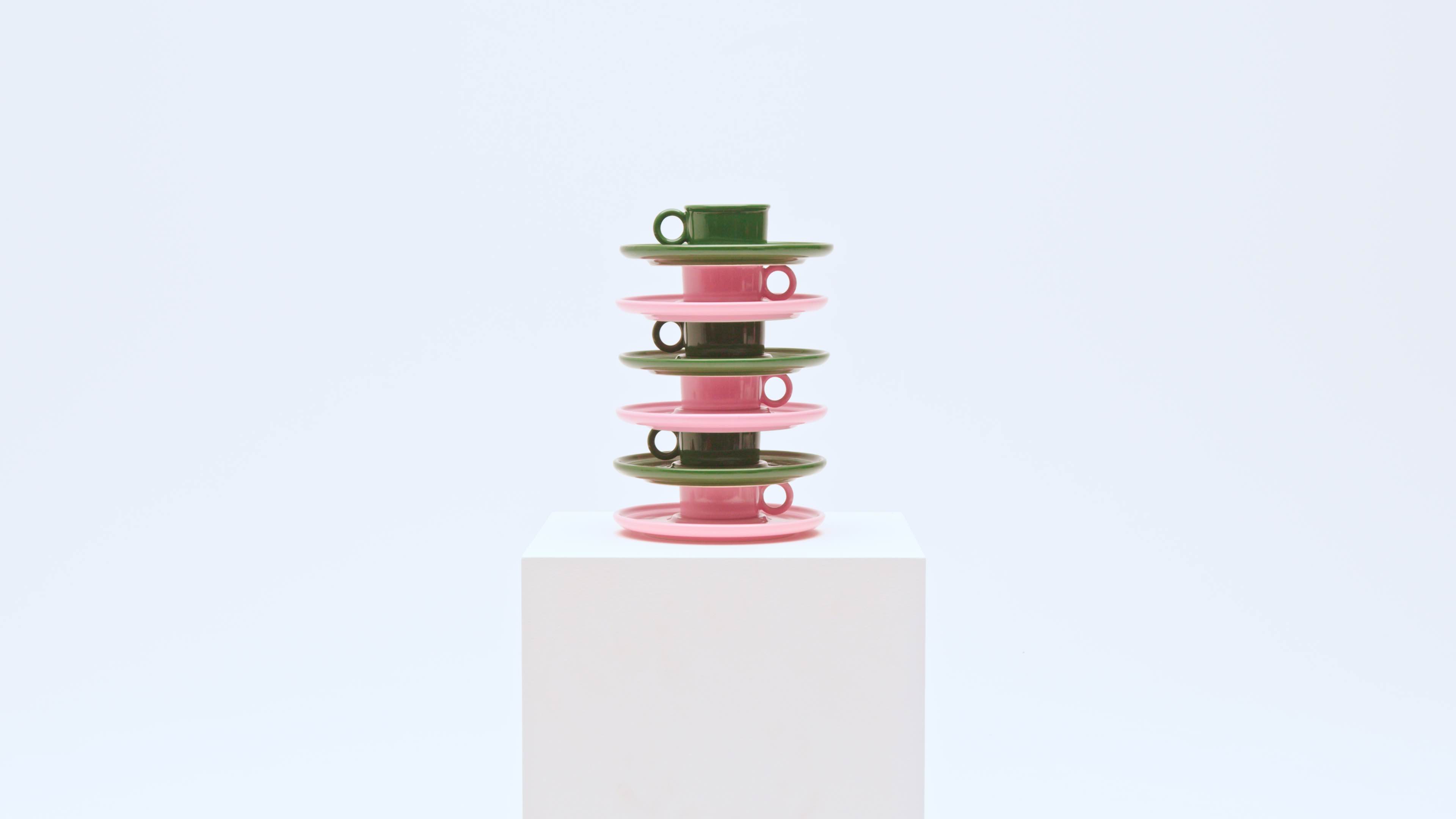 stack of pink and green porcelain teacups and saucers