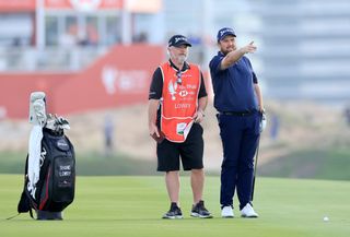 Lowry lines up a shot with his caddie