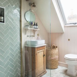 Pink en-suite bathroom with wall panelling, pastel tiles, upcycled vanity unit and counter top basin