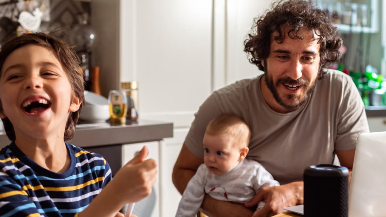 A smiling family in front of a computer