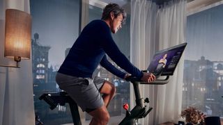 A man riding a peloton bike in his lounge