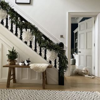 Christmas stair decor garland with paper decorations in white hallway