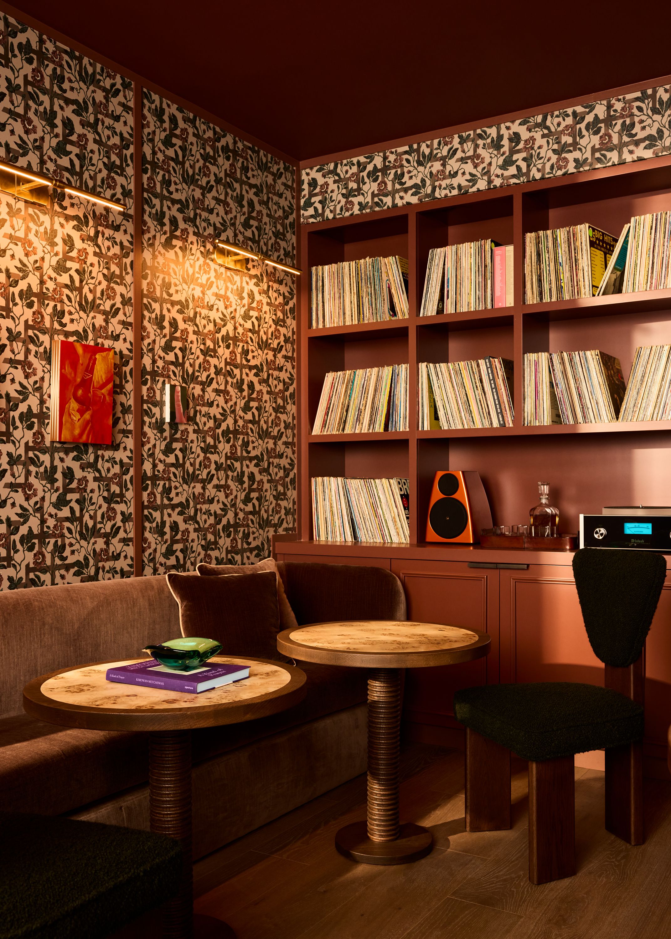 A wall of records with round tables and a velvet couch.