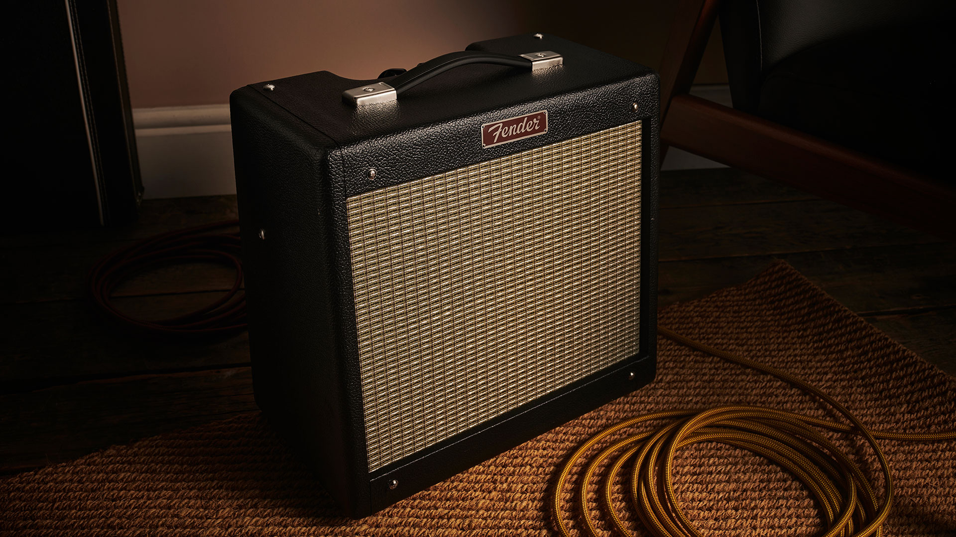 Fender Pro Junior Tube Combo Amp on a carpet in a low lit room, next to a guitar cable