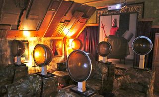 A home theatre in the attic features vintage beauty parlour hairdryer stations, arranged in neat rows