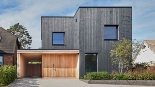 exterior of a modern detached black timber-clad self-build