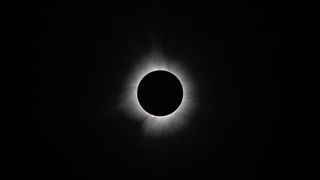 total solar eclipse april 2024 showing the white corona around the sun streaming out into space.