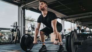 a photo of a man deadlifting with a barbell