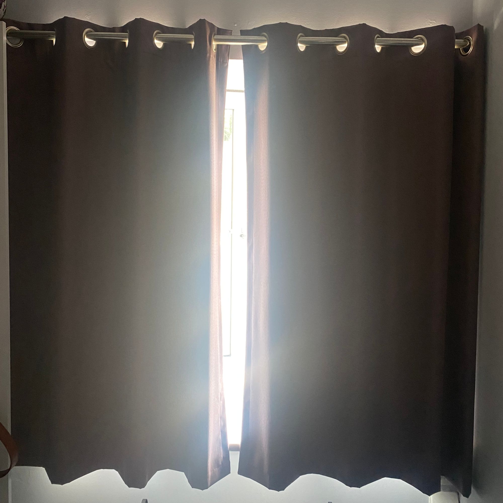 Blackout curtains over open window with gap in the middle