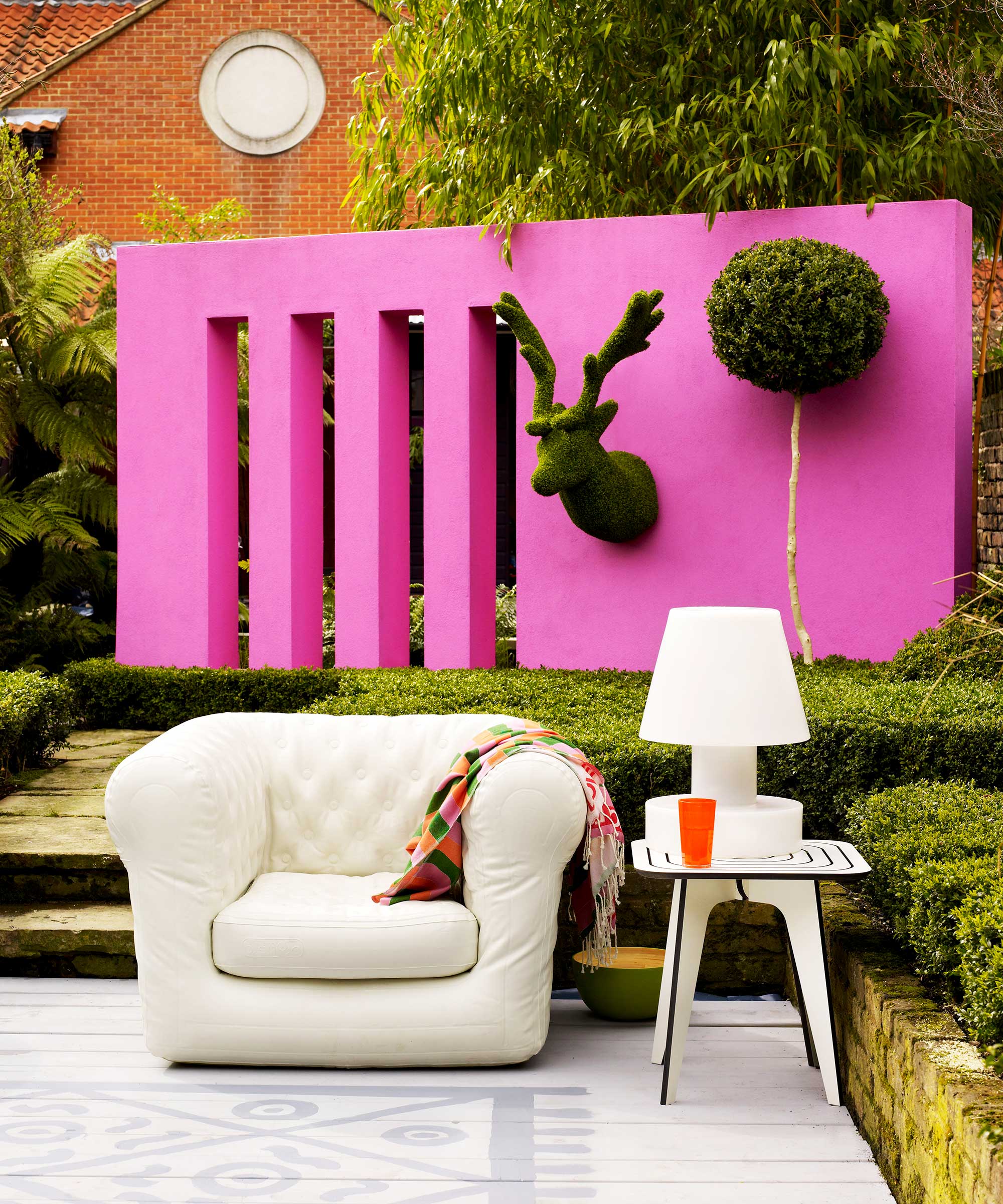 pink feature wall with animal topiary in modern garden