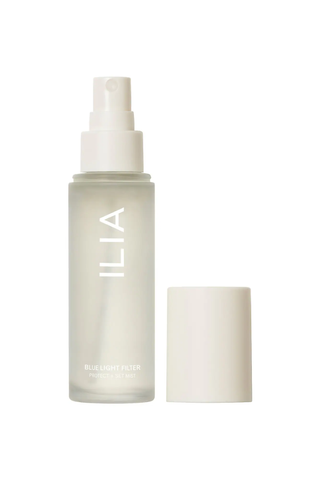 A clear, uncapped bottle of ILIA Blue Light Filter setting spray against a white background.