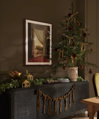 credenza styled for christmas with a velvet bow garland and mini christmas tree with ribbon bows