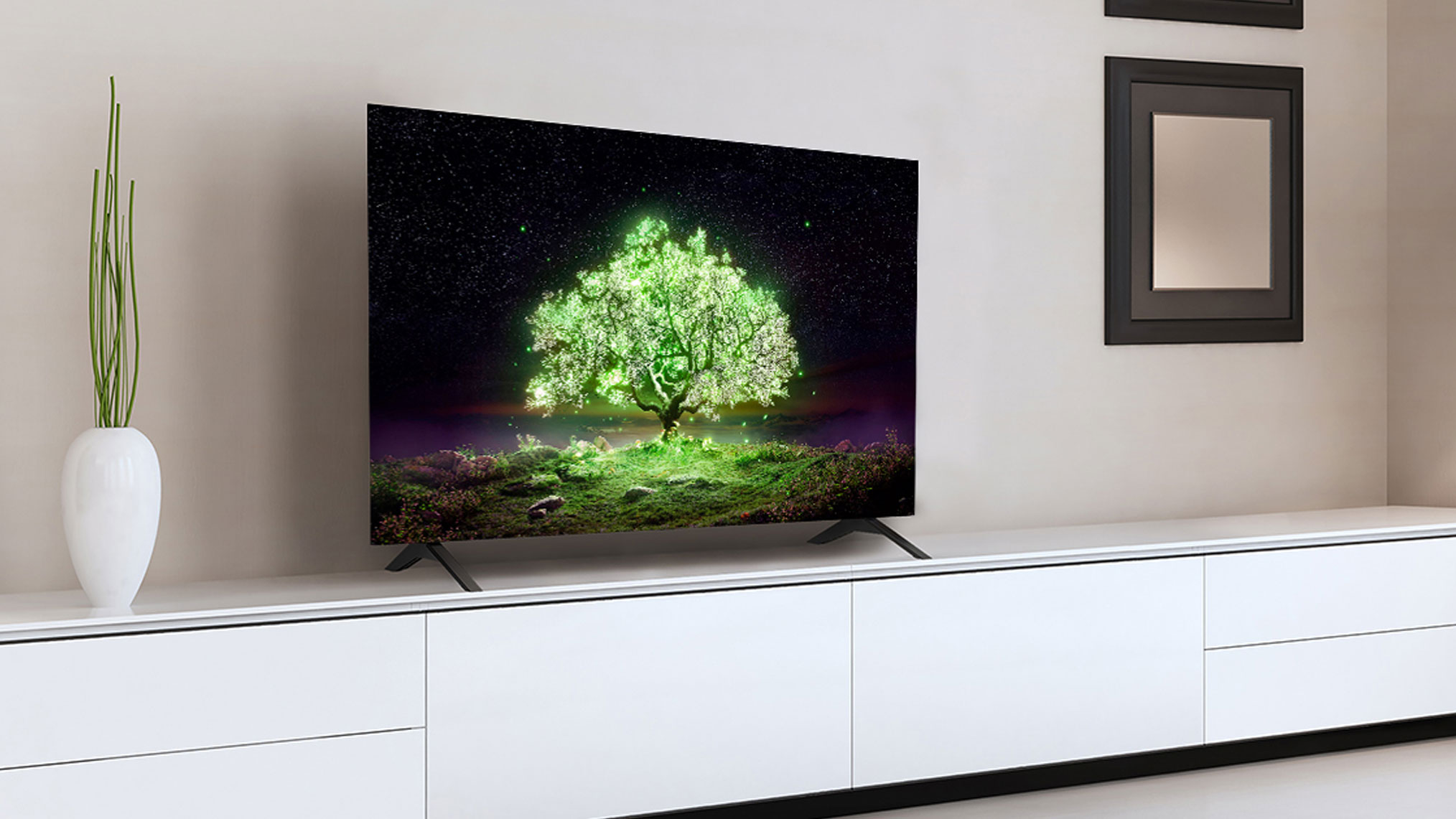 LG A1 OLED showing green tree on display, sitting on white countertop