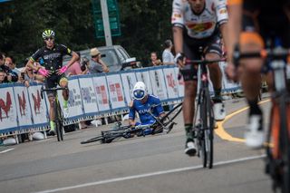 Travis McCabe sits on the ground after crashing during stage 2 at the Tour of Alberta