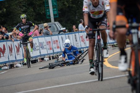 Travis McCabe sits on the ground after crashing during stage 2 at the Tour of Alberta