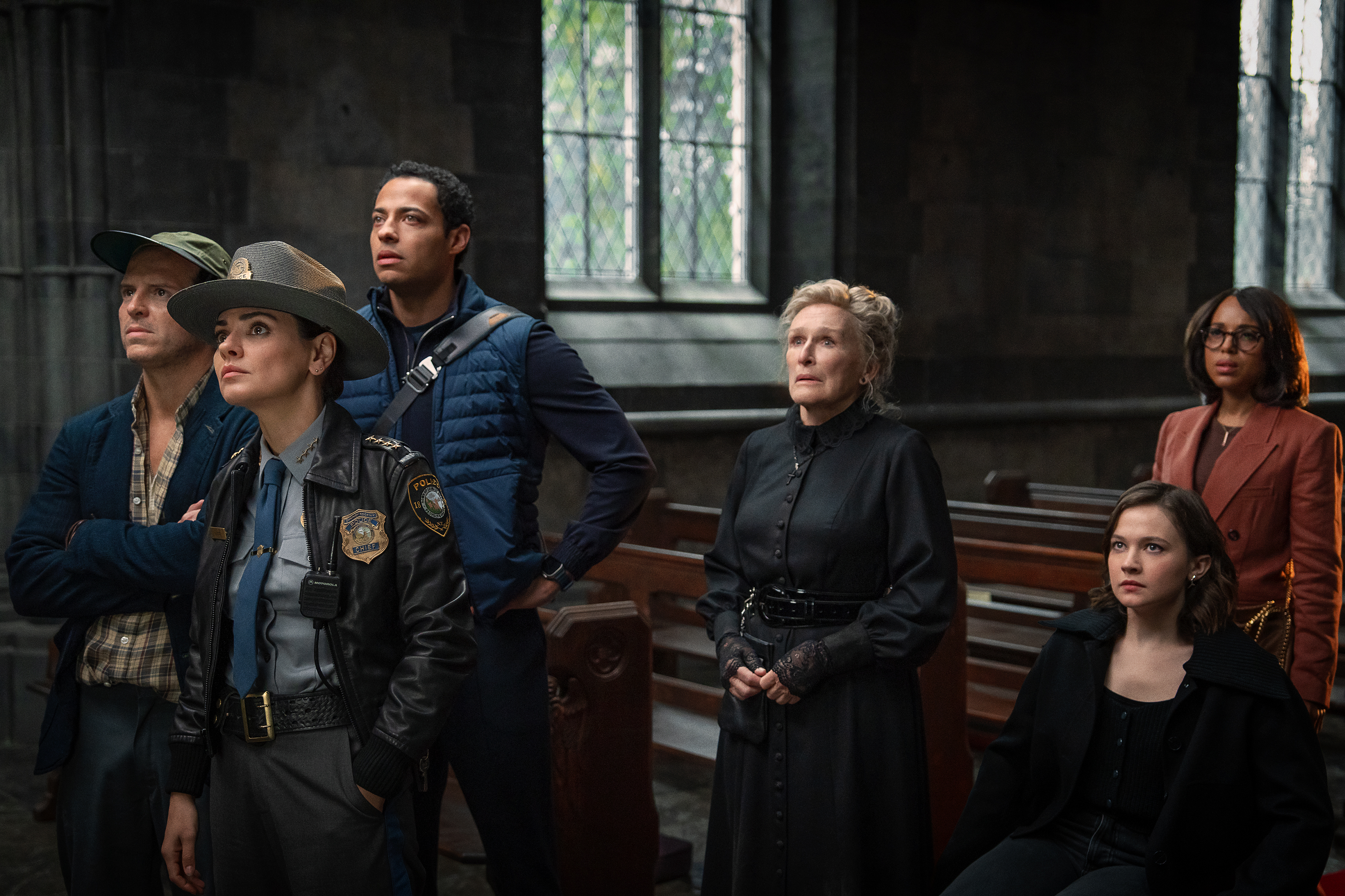 the cast of wake up dead man stand in an old church