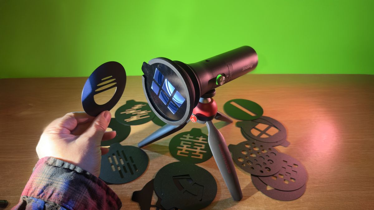 SmallRig RF 10C flashlight held in a hand shining on a greenscreen background