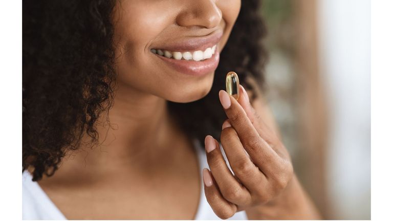 woman smiling taking the best vitamin for skin