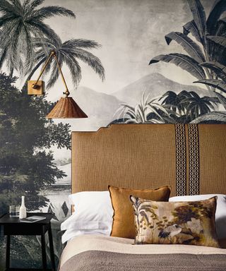 Bedroom wallpaper ideas featuring a gray tropical print with ochre headboard, cushions and wall lighting.