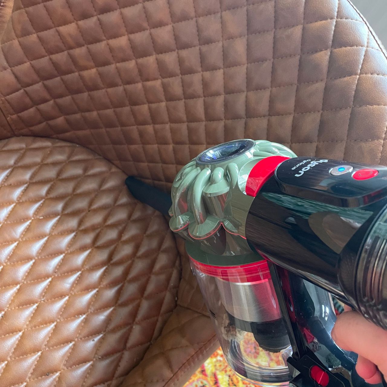 Using the Dyson V8 Cyclone and crevice tool to clean brown leather dining chairs